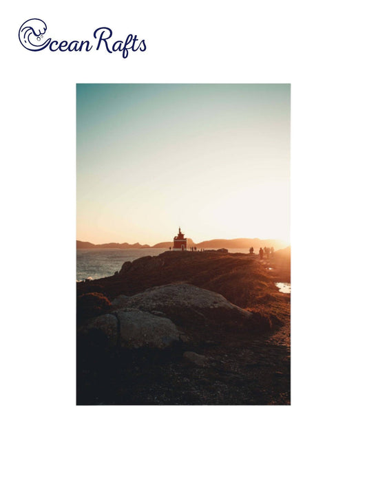 Sunrise Beach Poster - home decor beach poster image of a light house in the distance with people walking to and from it along a pathway. Sunset in the background surounded by the ocean Canvas Frame Poster New Cheap Free Delivery $30 | Ocean Rafts