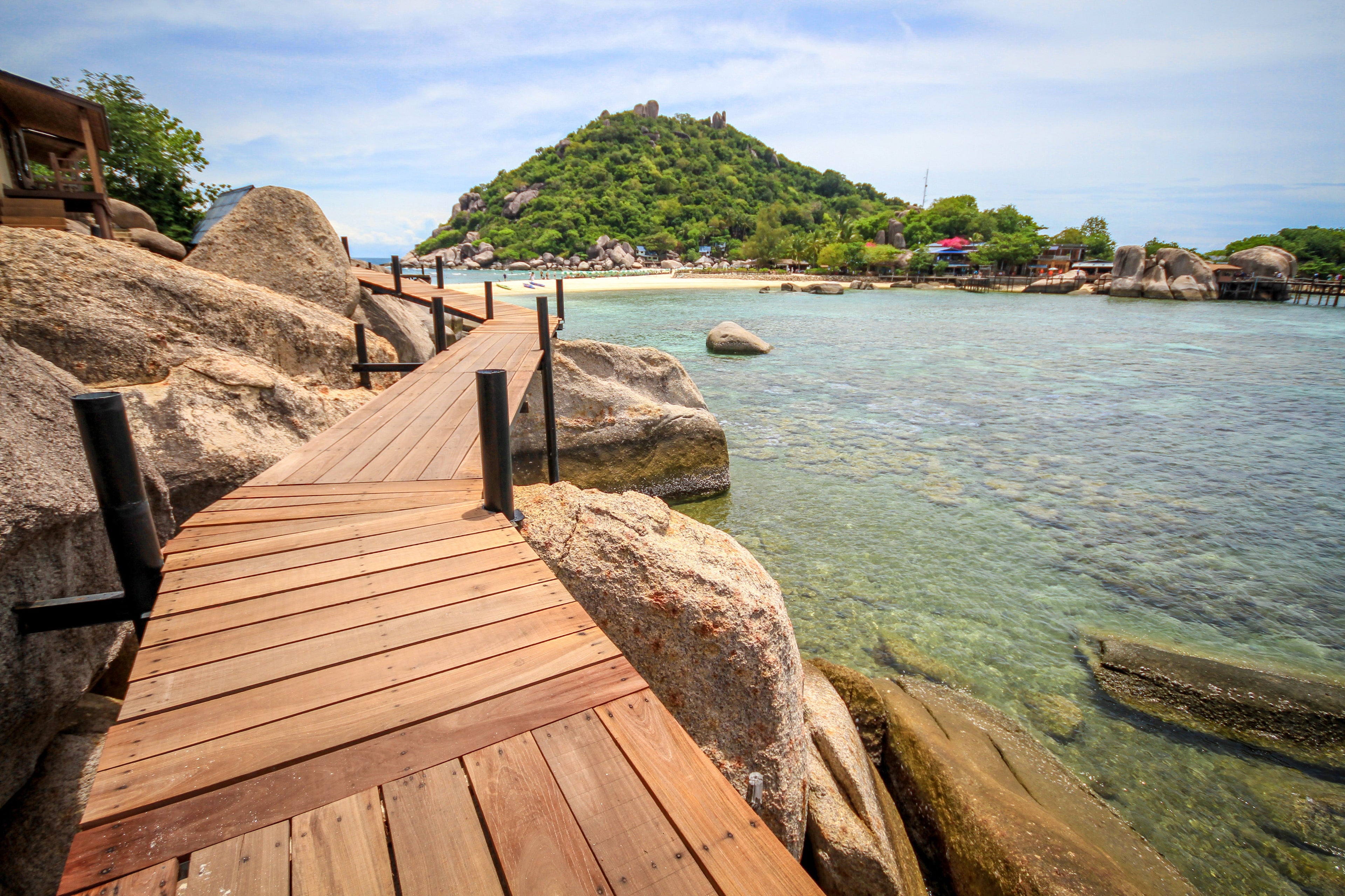 boardwalk between rocks and ocean with tropical beach and island www.oceanrafts.com ocean rafts home page